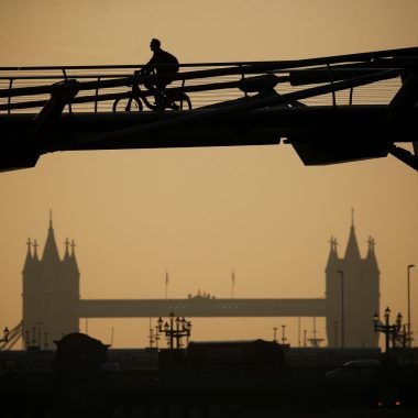 A person cycles across Millennium Bridge as the sun rises, in London, Britain, September 15, 2020. REUTERS/Henry Nicholls - RC2VYI9YSS3Z